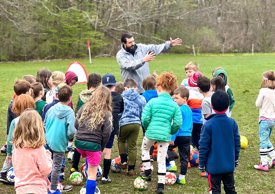 Coach directing young soccer players